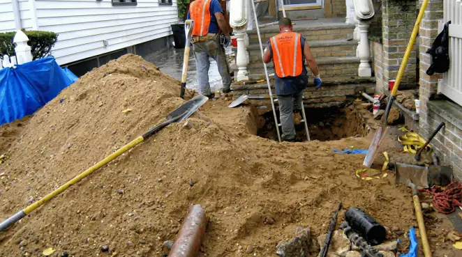 Contractors performing foundation protection and exterior drainage excavation near residential home steps in Scottsdale, AZ